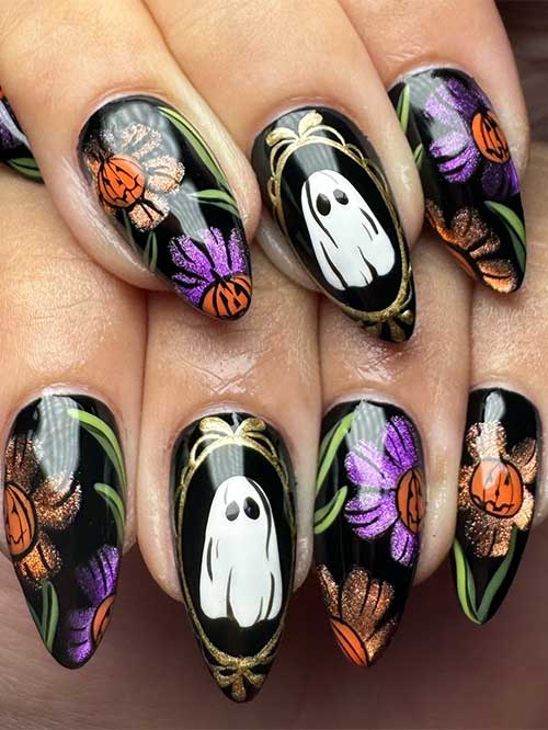 Black pumpkin nails for Halloween with glitter floral pumpkins and a ghost accent nail design.