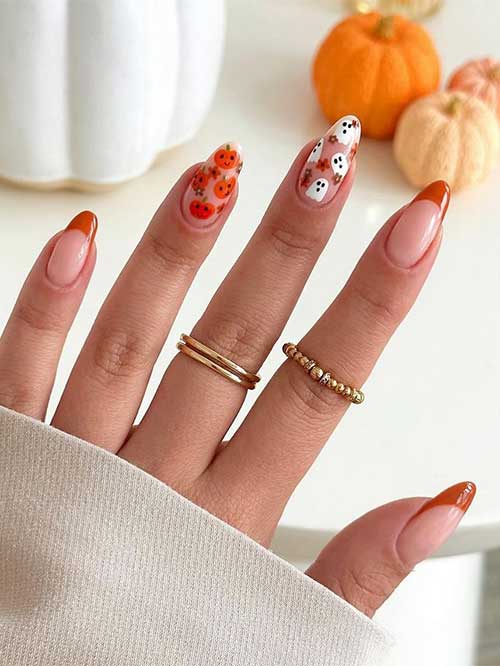 Burnt orange French pumpkin nails with floral and pumpkin designs on two nude accent nails, showcasing autumn elegance.