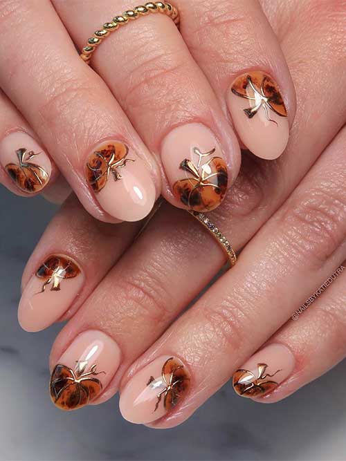 Tortoiseshell pumpkin nails with gold chrome accents on a nude base, showcasing a stylish and playful design.