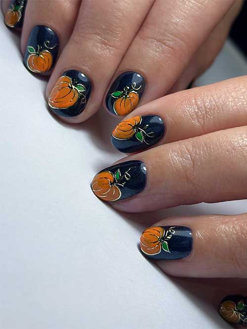 Short black nails featuring orange pumpkins with elegant gold chrome outlines for a festive and stylish look.