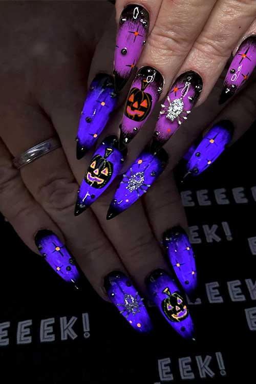 Long stiletto black and purple witch glow-in-the-dark nails, adorned with pumpkins and silver rhinestone spiders