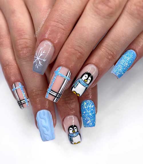 Frosty blue and nude Christmas nails adorned with glitter, plaid, sweater designs, snowflakes, and a cute penguin motif.