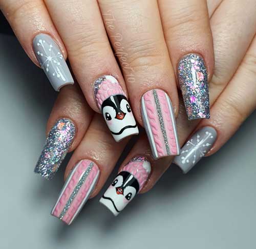 Grey and pink Christmas nails featuring sweater nails, snowflakes, glitter, and penguin nail art on an accent nail.