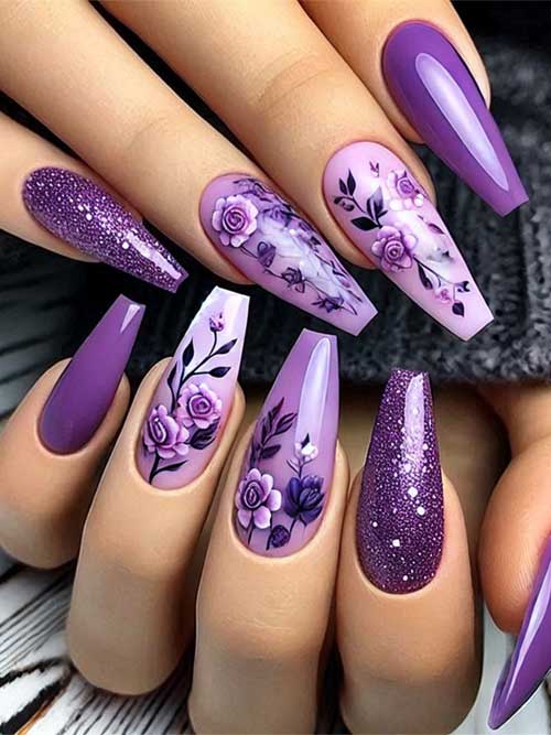 Purple coffin-shaped nails featuring a floral design and sparkling glitter accents for a stunning look.