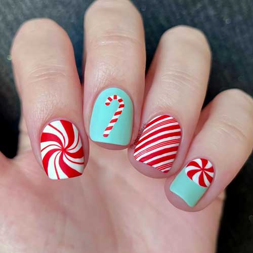 Short candy cane nails with two accent nails featuring candy cane designs on a mint green base color.