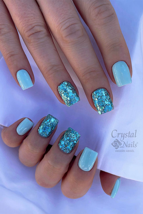 Square shaped short light blue nails with glitter light blue on two accent nails