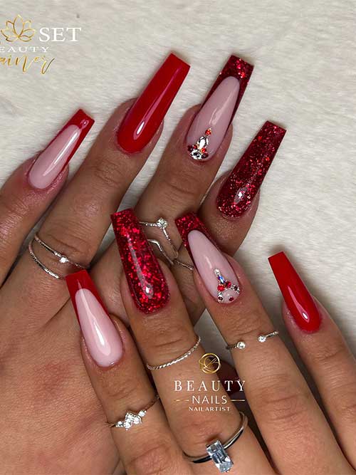 Long coffin red nails with French tips, featuring glitter encapsulation and rhinestone accents for a glamorous look.