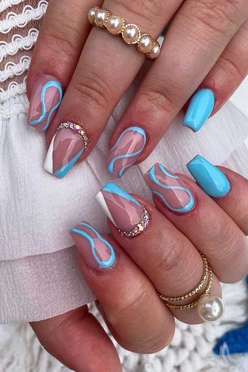 Medium coffin light blue nails with light blue swirls on two accent nude nails. Besides, a light blue and white V French tip