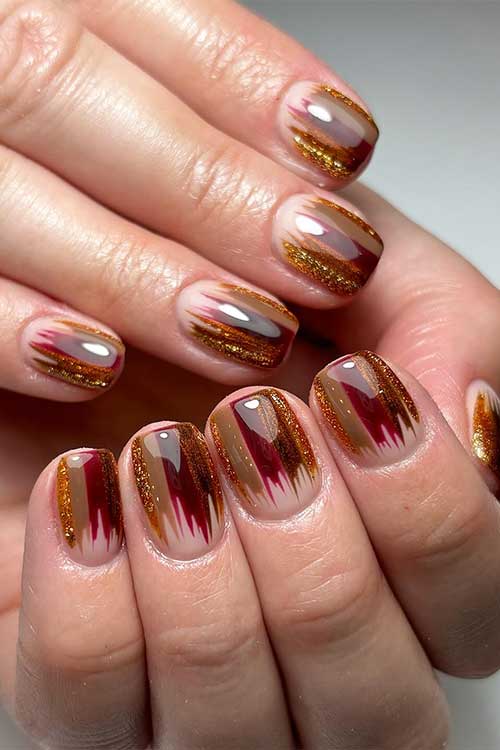 Creative short fall nails showcase a vibrant blend of brown, glitter, and burgundy in a unique line nail art design.