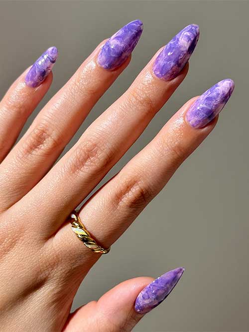 Almond-shaped nails featuring a stunning rose and purple marble design, showcasing elegance and artistic flair.