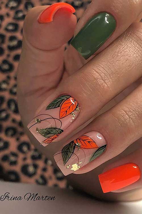 Dark olive green fall nails and neon orange nails with leaf nail art on two accent nude nails decorated with gold foil