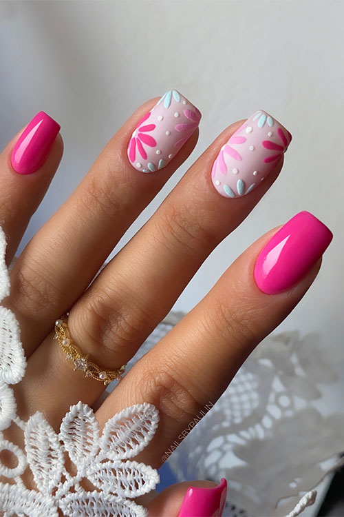 Hot pink short spring nails with two nude accent nails adorned with light blue, light pink, and hot pink flowers