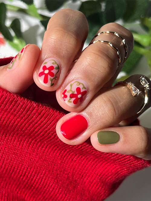 Red and green short spring nails feature nude pink nails adorned with red flowers and green grass