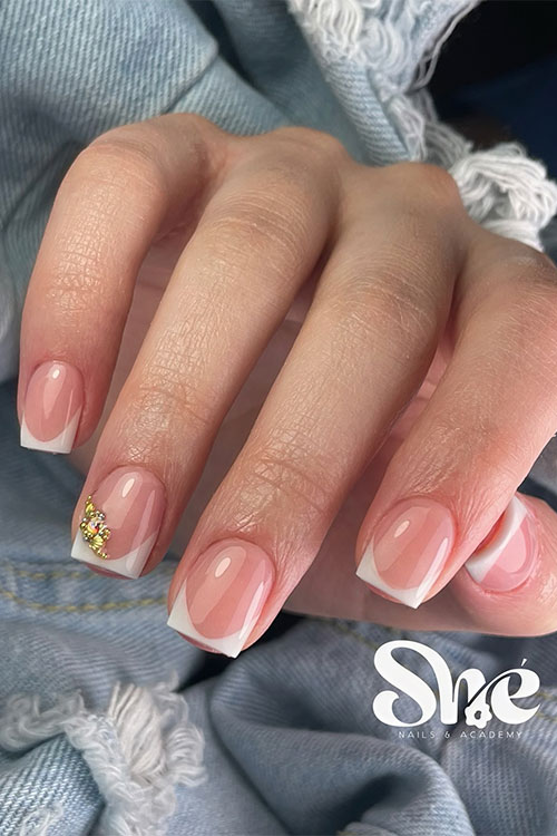 Square-shaped classic white French tip nails with gold rhinestones on the ring fingernail are cute summer nails