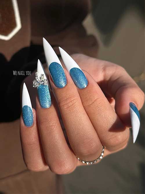 Long stiletto nails with sparkling blue base color and white French tips and silver rhinestones on an accent nail