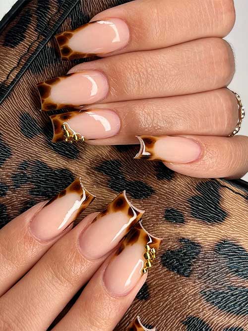 Long square-shaped French tortoise nails adorned with gold rhinestones on the ring French tip design.