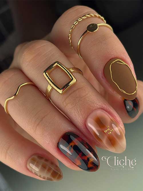 Short fall nail design with tortoise accents, snake print, floral with gold rhinestones, and matte light brown with gold gel.