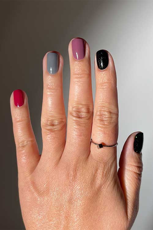 Short multicolored fall nails featuring shades of mulberry, torrential, cardigan, and stargaze by Olive & June Quick Dry Polish.