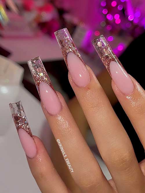 Sparkling French nails over a nude pink base color feature long clear tips decorated with copper and gold sequins