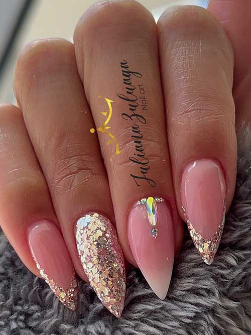 V-shaped gold glitter sparkling French nails with a pink and white French ombre nail adorned with rhinestones