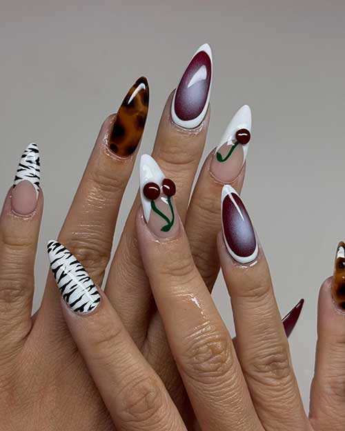 Chic white French tips embellished with cherries and zebra patterns, paired with two tortoise accent nails for added flair.