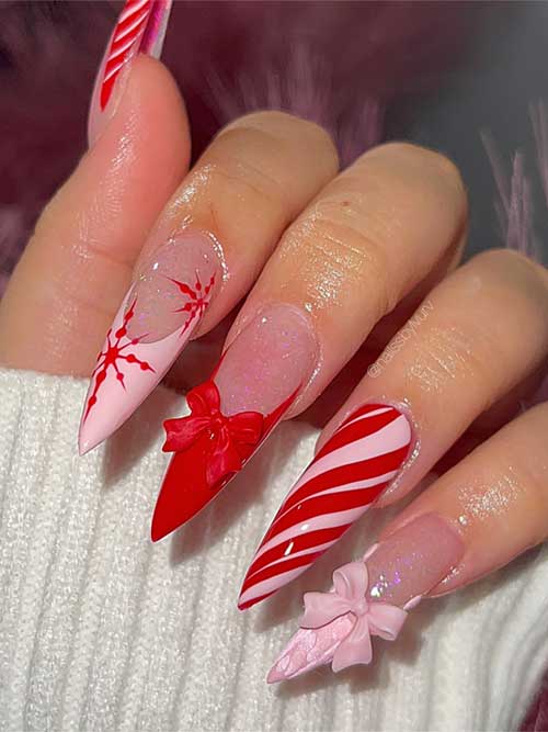 Long stiletto-shaped red and pink Christmas nails with sweater, snowflake art, and an accent candy cane design.