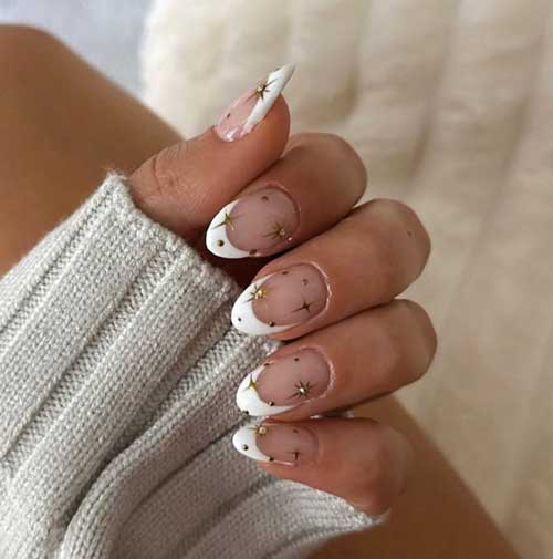 Elegant almond-shaped white French nails adorned with delicate gold stars for a chic and stylish look.