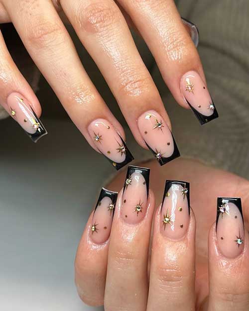 Long coffin-shaped French nails adorned with elegant gold star designs, showcasing a classic and stylish manicure.