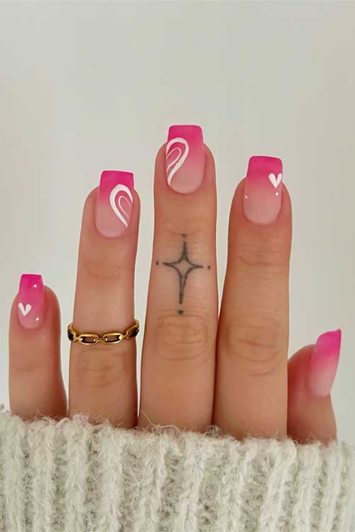 Beautiful ombre nails in shades of pink, from light to hot, decorated with lovely white hearts for a sweet finish.