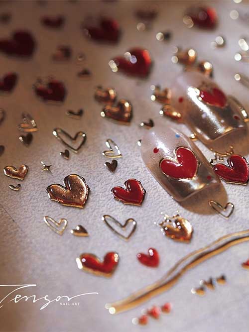 Red and gold heart nail stickers for Valentine's Day, perfect for DIY manicures. Self-adhesive and embossed for a stylish look.