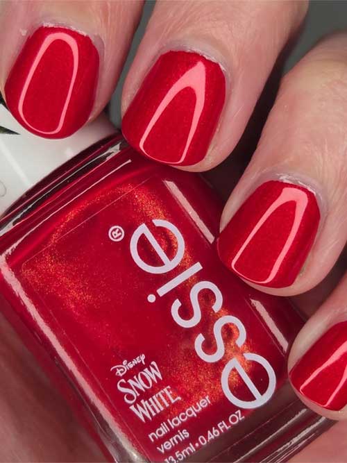 Deep red nail polish named "Just Take a Bite" from essie's Snow White Collection, featuring a hypnotic finish.