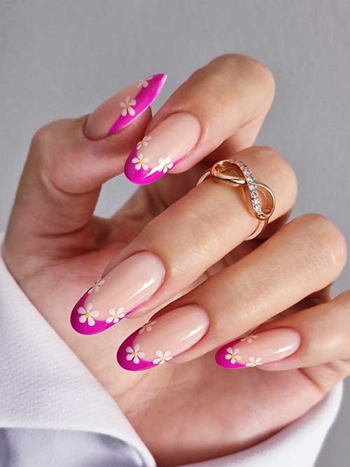 Elegant nude nails featuring vibrant pink tips and delicate white daisies, perfect for a fresh spring look.