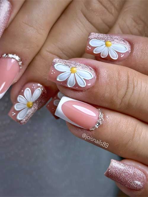 Softgel floral nails in pastel and glittery pink, featuring 3D white daisies, French tips, and rhinestones.